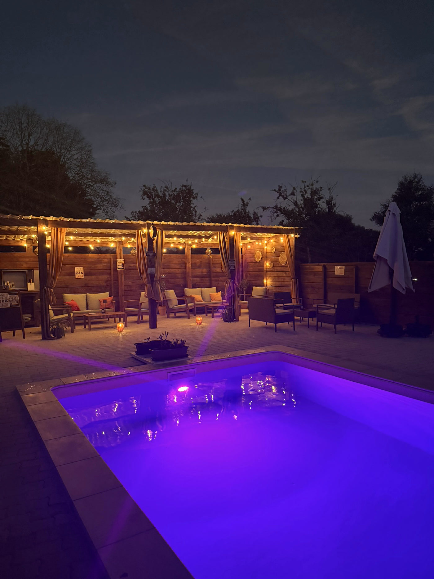 La piscine et le bar des Gîtes du Petit Marcel à la nuit tombée