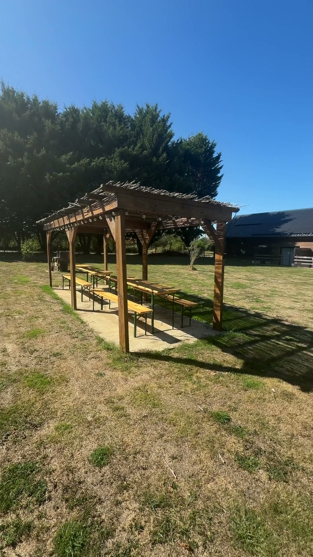 La pergola et les grandes tables au cœur du parc